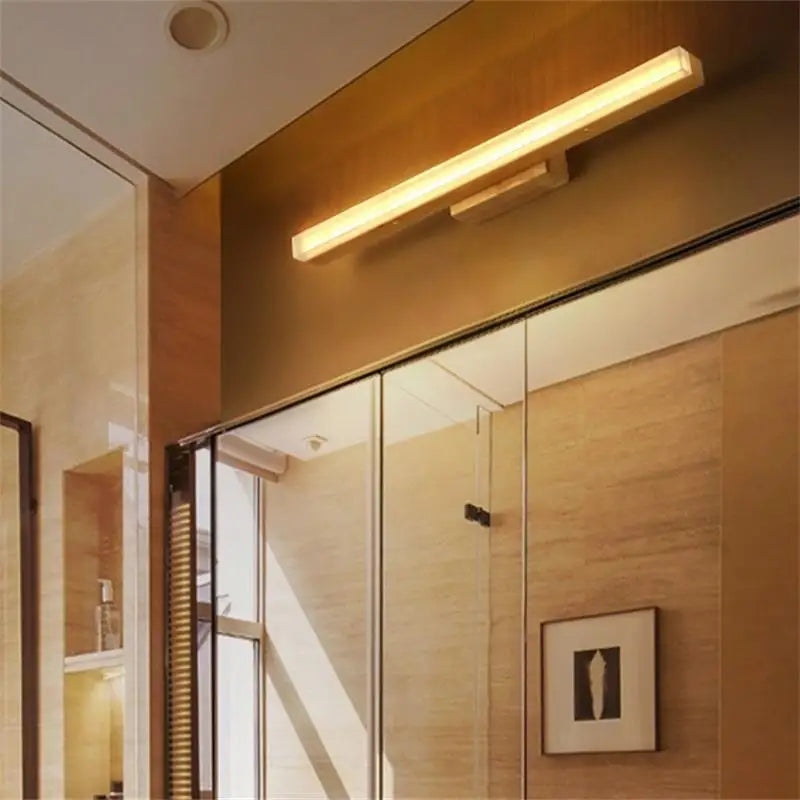 Linear wood sconce above a bed