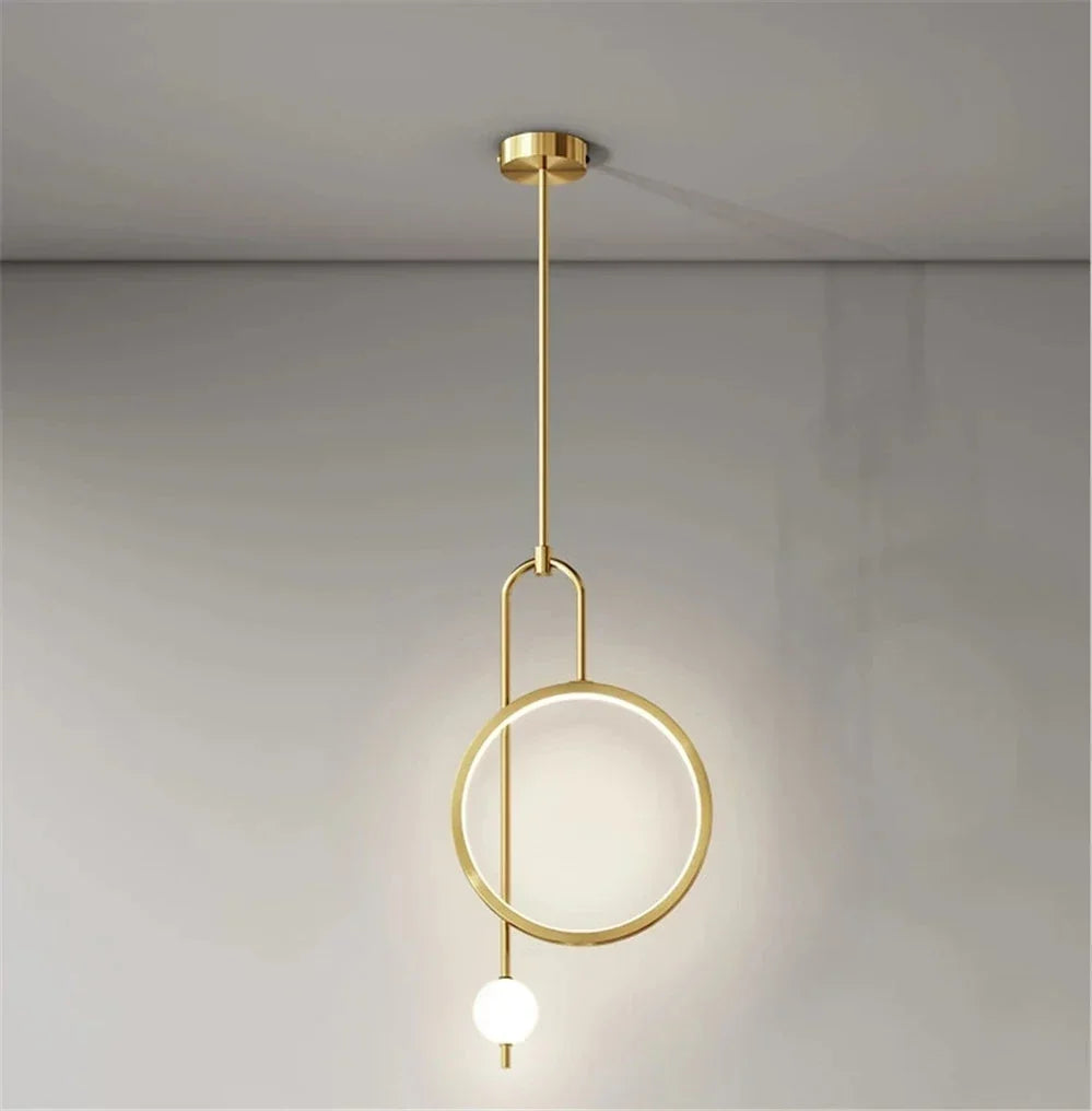 Gold ring pendant beside a bed