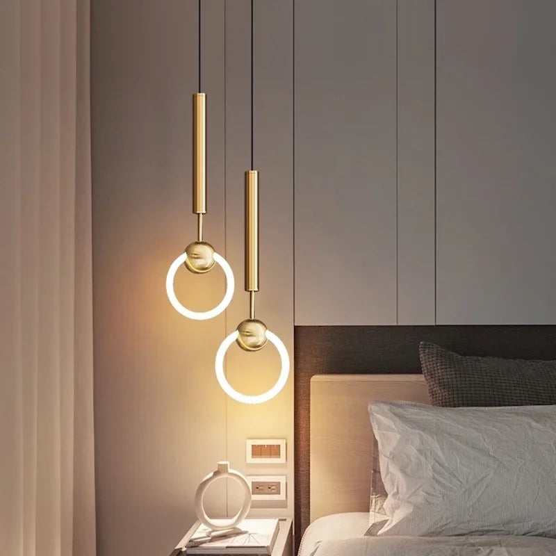 Gold minimalist pendant beside a bed