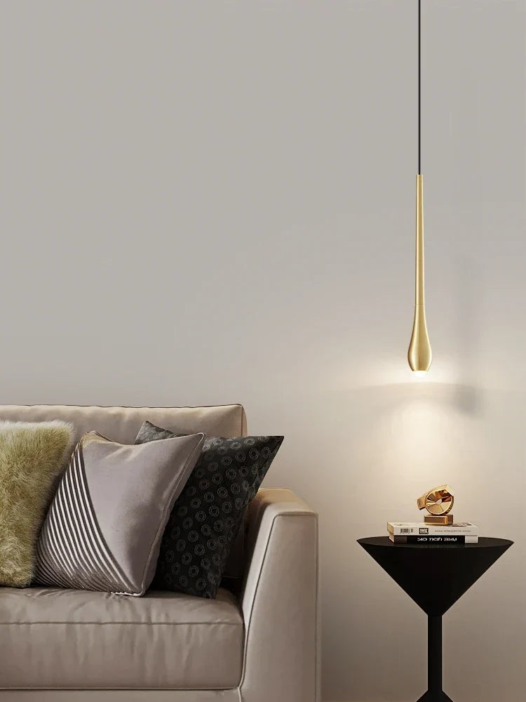 Gold drop pendant by a bed