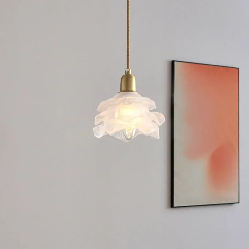 Glass flower pendant beside a bed