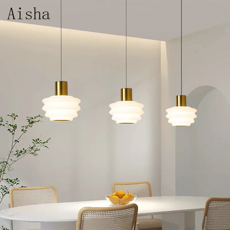 Gold acrylic pendant beside a bed