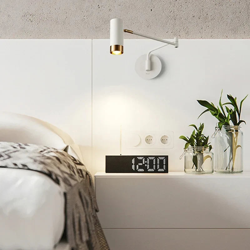Folding arm sconce beside a bed