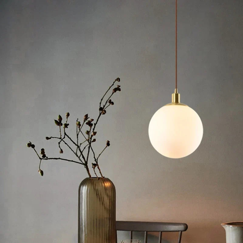 Glass orb pendant by a bed