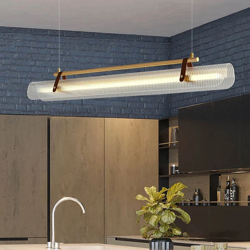 Gold linear pendant over a kitchen island