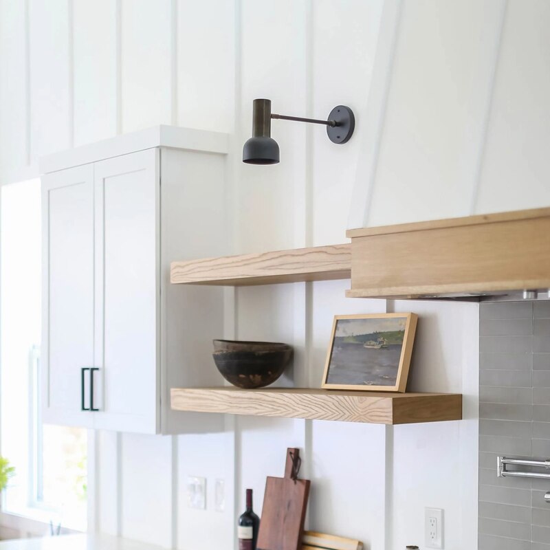 Adjustable arm wall light by a reading chair